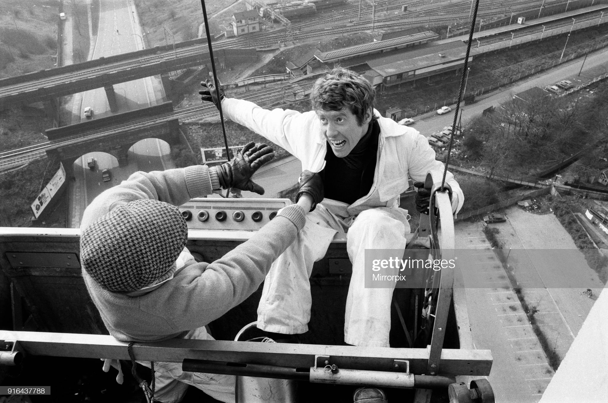 Actor Michael Crawford pictured during filming at Station House, a 200 foot high building on the North Circular Road in London with stuntman Derek Ware for the BBC television comedy series 'Some Mothers Do Ave Em', 10th March 1973. (Photo by Harry Fox/Mirrorpix/Getty Images)