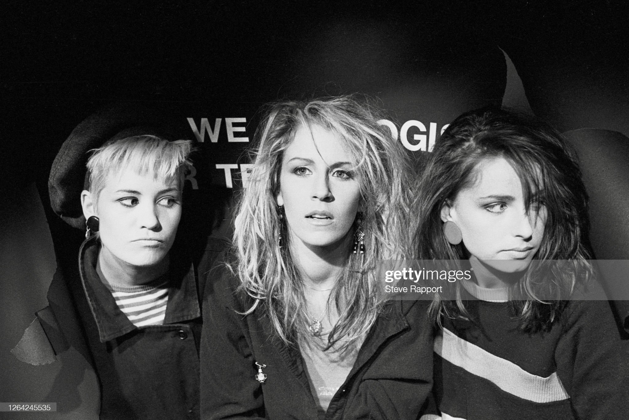 Members of Pop group Bananarama film the 'Rough Justice' music video, 5/4/1984, poking their head through the breakdown caption. (Photo by Steve Rapport/Getty Images)