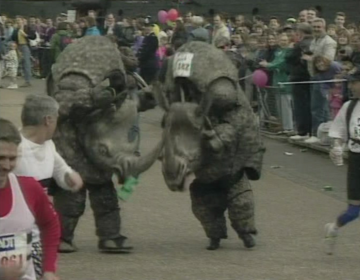 Two people (supposedly Smashie and Nicey) in rhino costumes running a marathon