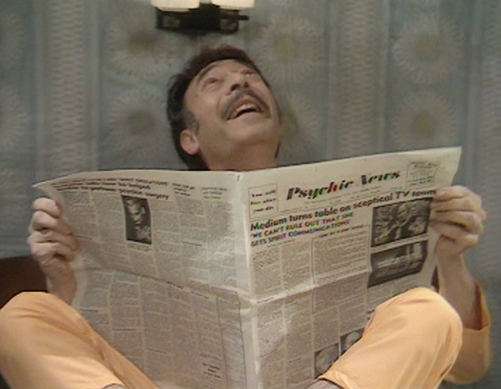 We reveal that the copy of Psychic News is being held by Kenny. He's looking upwards at Frank and Betty's room in a faintly alarmed manner.