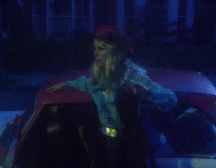 Patsy, standing by the car in the flashback scene