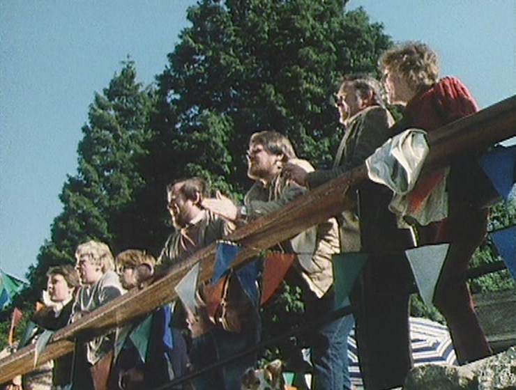 Onlookers watching the race, with a beautiful blue sky behind them
