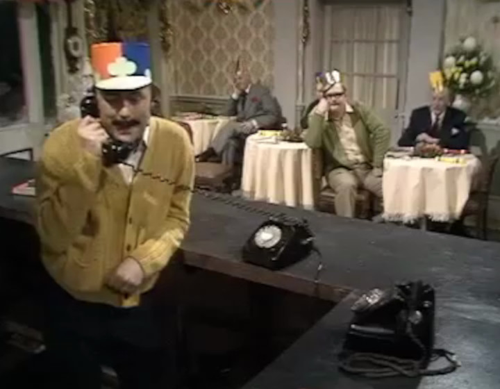 The Mike Yawood Show: Yarwood as Basil, with various guests sitting along the wall to the dining room